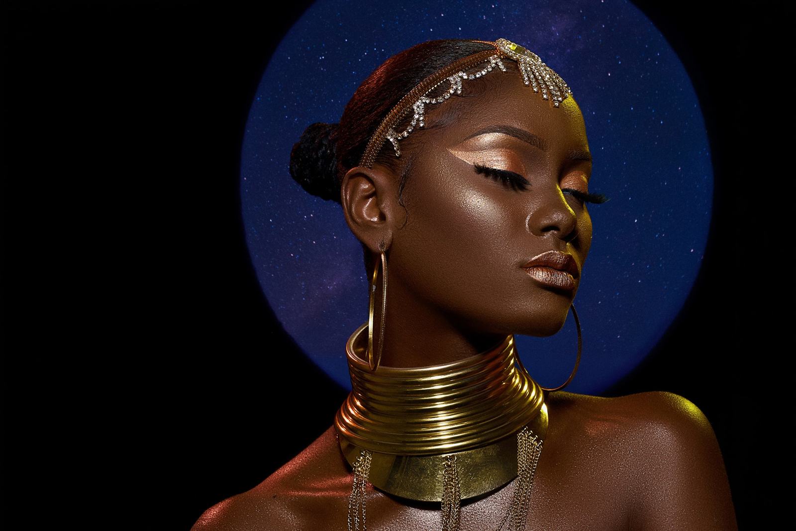 Beauty portrait with gold neck rings and a blue halo