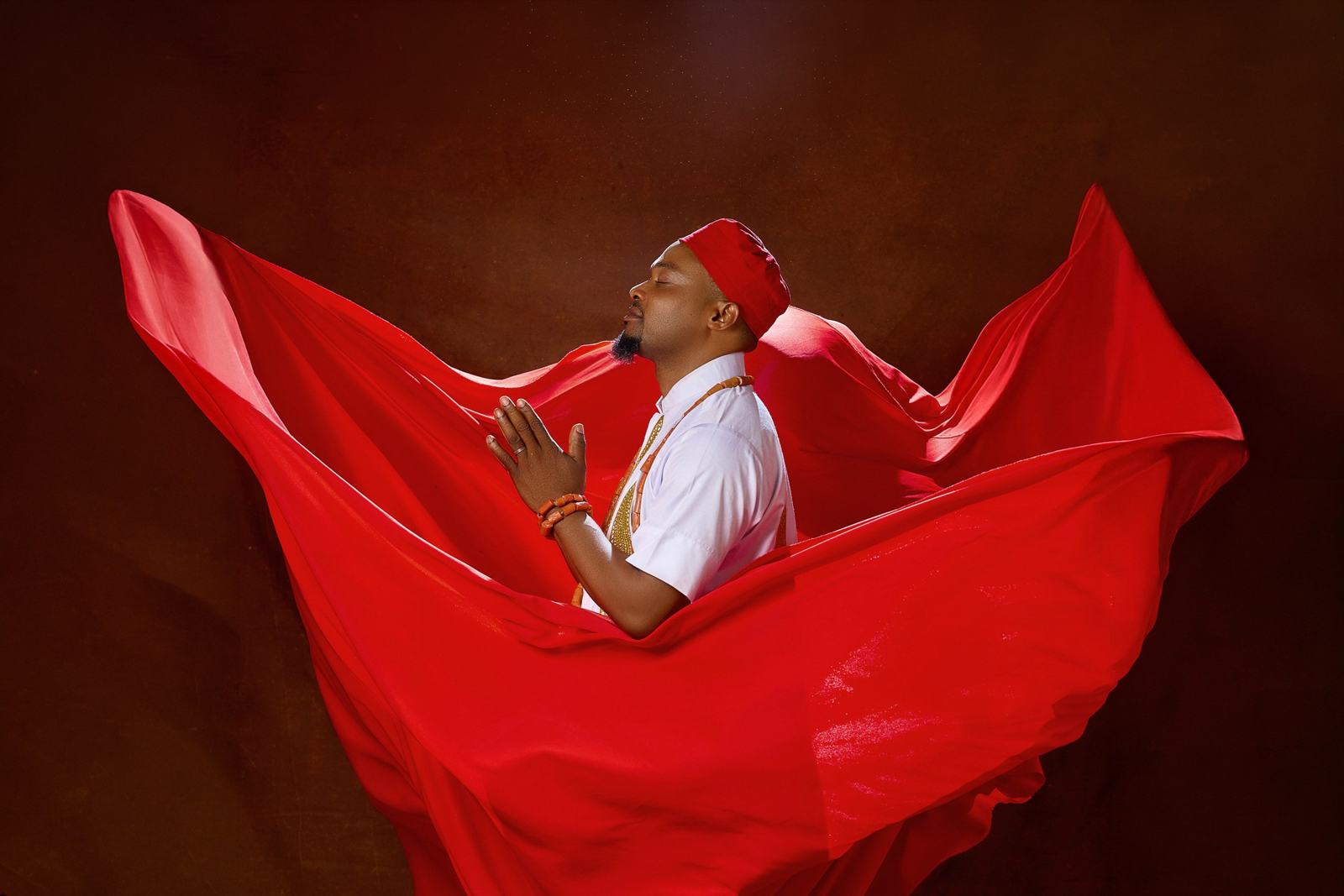 Man surrounded by billowing red fabric