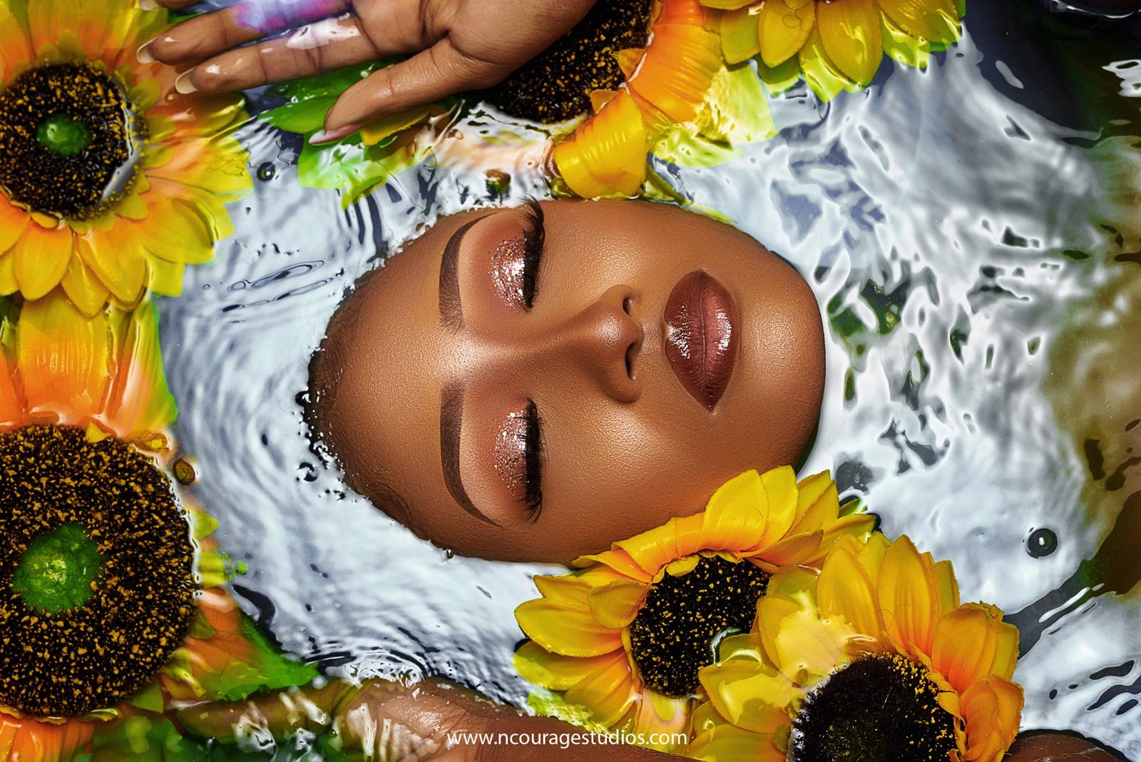 Face resting in water surrounded by sunflowers